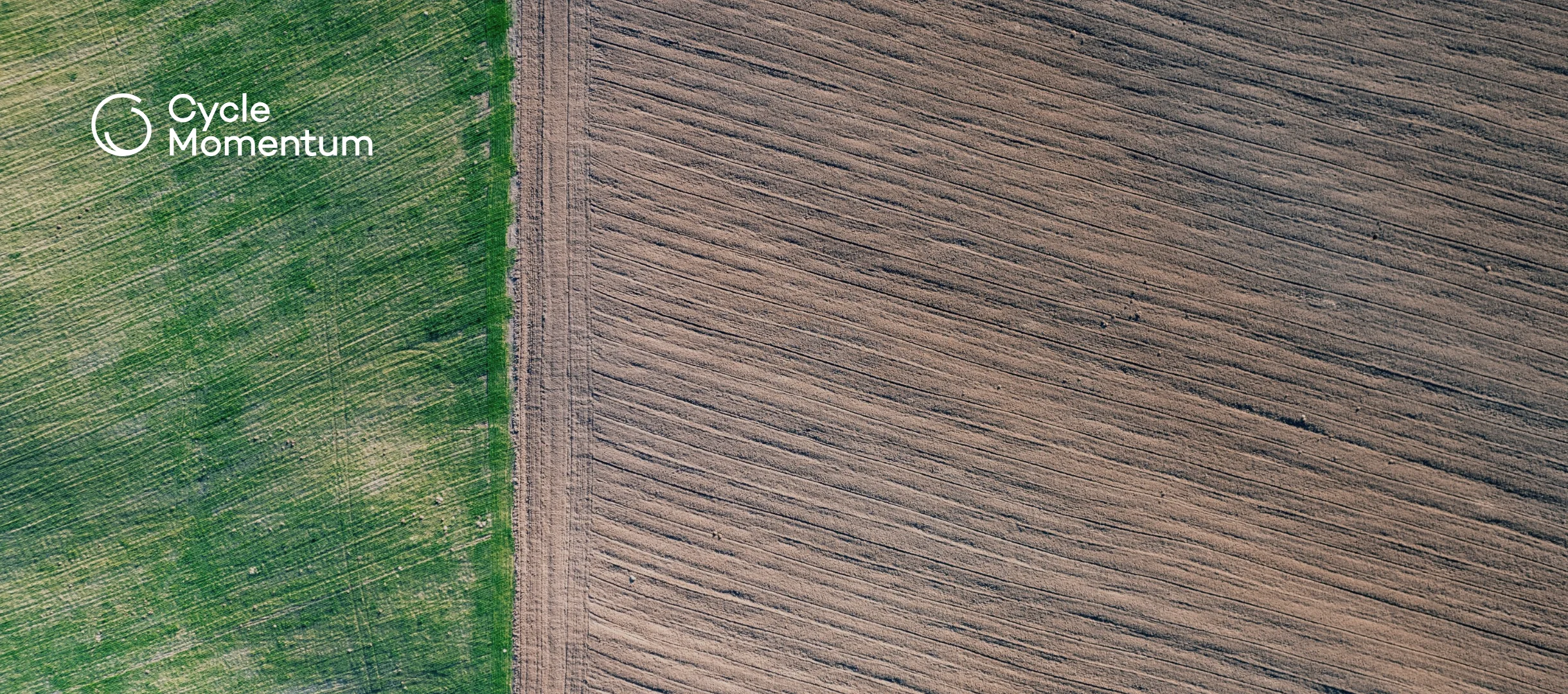 Aerial view looking straight down on bare tilled brown soil beside a strip of green crop